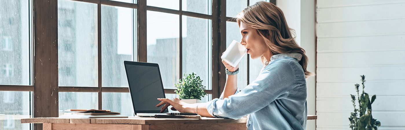 Femme travaillant en home office devant son ordinateur grâce à la solution Xerox® Docushare® Go