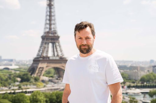 Un homme avec une barbe devant la Tour Eiffel