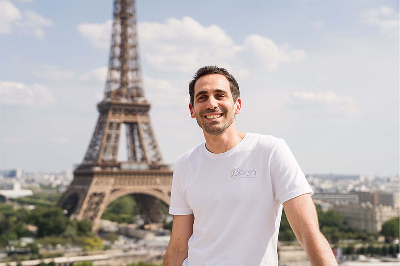 Homme tee shirt blanc pose devant la Tour Eiffel