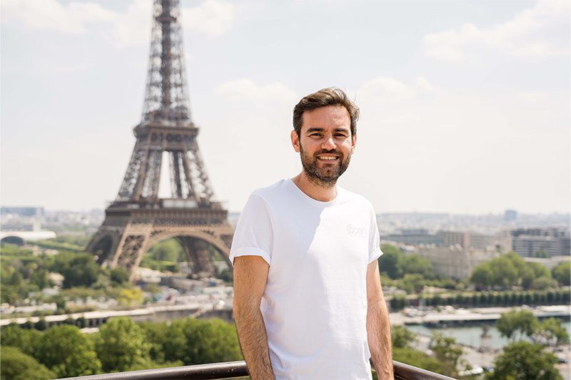 Un homme seul pose devant tour Eiffel.